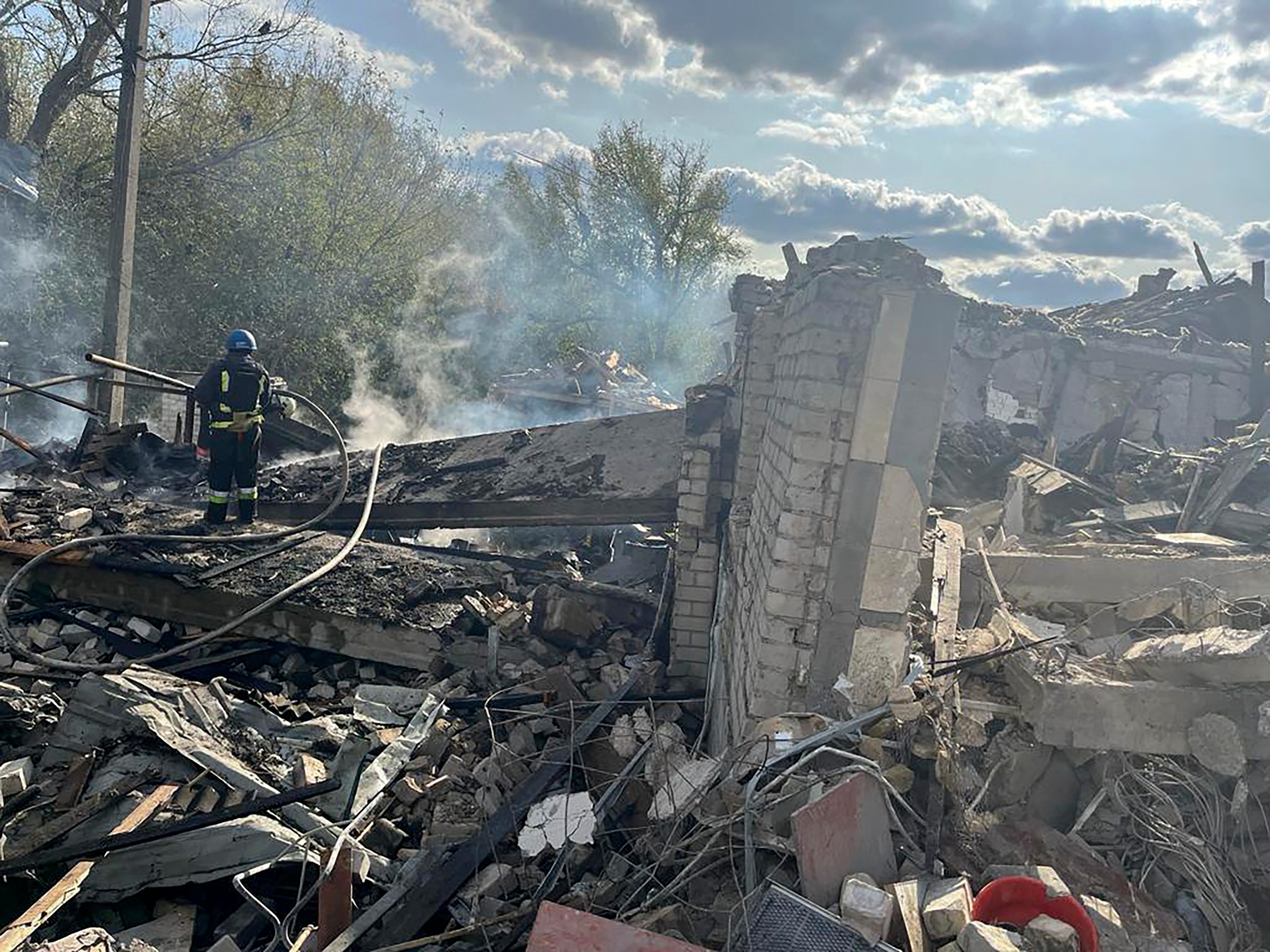 Na snímke hasiči hasia požiar po ruskom raketovom útoku na dedinu Hroza v Charkovskej oblasti.