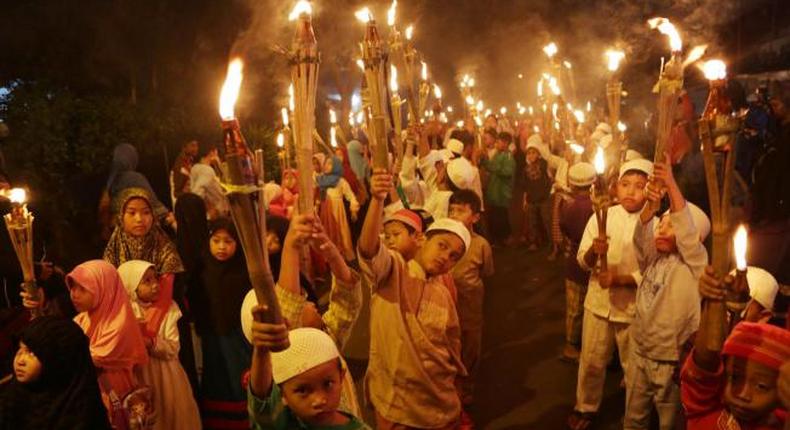 Indonesian Muslim children carry torches  to celebrate the start of Ramadan