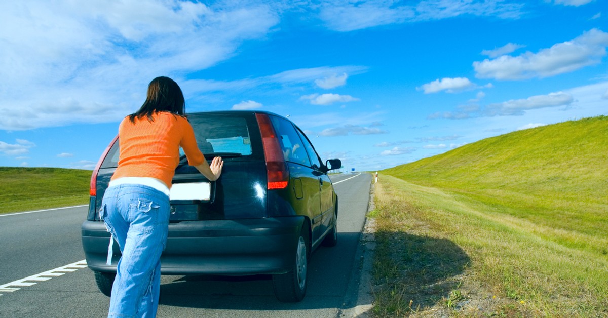 сломалась машина на дороге. девушка толкает авто. машина в луже. машина заглохла на дороге. машина заглохла.