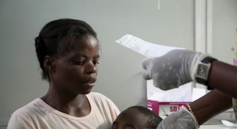 A mother holds her son suffering from yellow fever as she waits for a prescription at a hospital in Luanda?, Angola, March 15, 2016. 