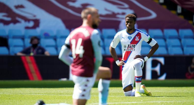 Wilfried Zaha (right)takes a knee prior to Crystal Palace's Premier League match with Aston Villa on Sunday