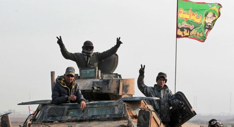 Iraqi forces members advance in the village of Arabat, south of Mosul, as temperatures continue to drop, on December 1, 2016