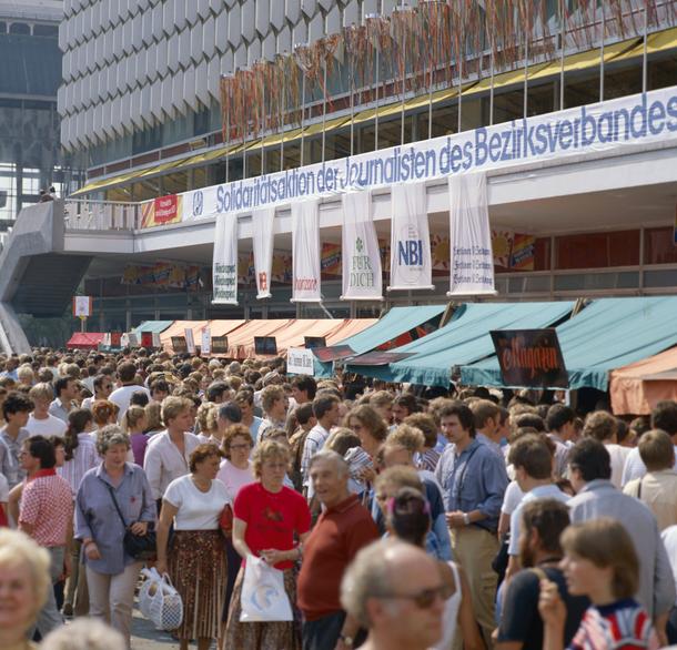 Ludzie przechadzają się po dorocznym bazarze stowarzyszenia dziennikarzy NRD VdJ w Berlinie Wschodnim w NRD w sierpniu 1985 r. 