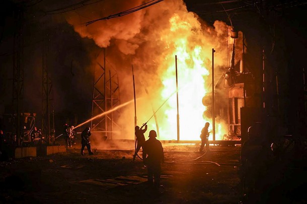 Ukraińscy ratownicy gaszą pożar po tym, jak rakieta uderzyła w obiekt infrastruktury w Charkowie na Ukrainie.