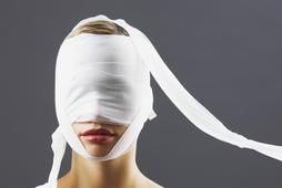 Bandage covering woman's face