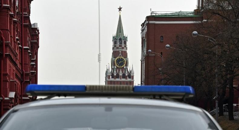 A group of men pictured through a police car window in central Moscow, with the Kremlin's Spasskaya (Saviour) Tower seen in the background, on March 1, 2017