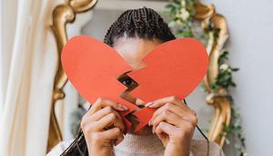 A woman holding a broken heart made of paper [Image: Antoni Shkraba]