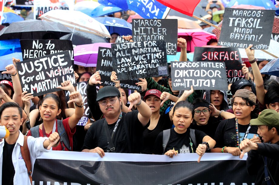 Demonstrators give a thumbs-down sign during a protest denouncing the burial of late dictator Ferdinand Marcos at the Libingan ng mga Bayani (Heroes' cemetery), at Luneta park, metro Manila, Philippines, November 25, 2016.