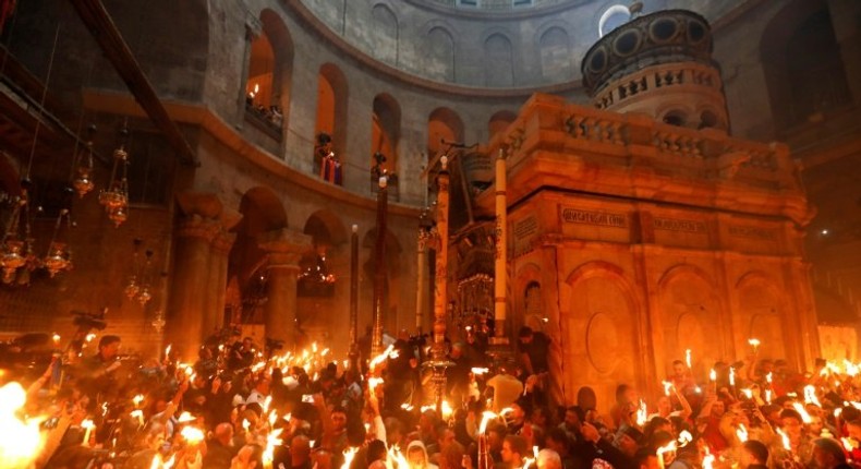 Christian Orthodox worshippers hold candles during the ceremony of the Holy Fire in the Church of the Holy Sepulchre in Jerusalem's Old City on April 15, 2017