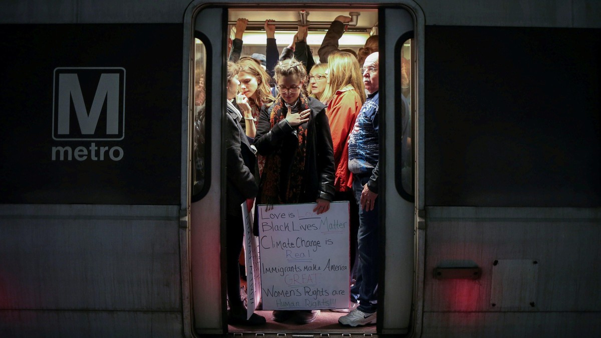 A woman activist holds placard on Metrorail on way to Women's March in Washington, D.C.