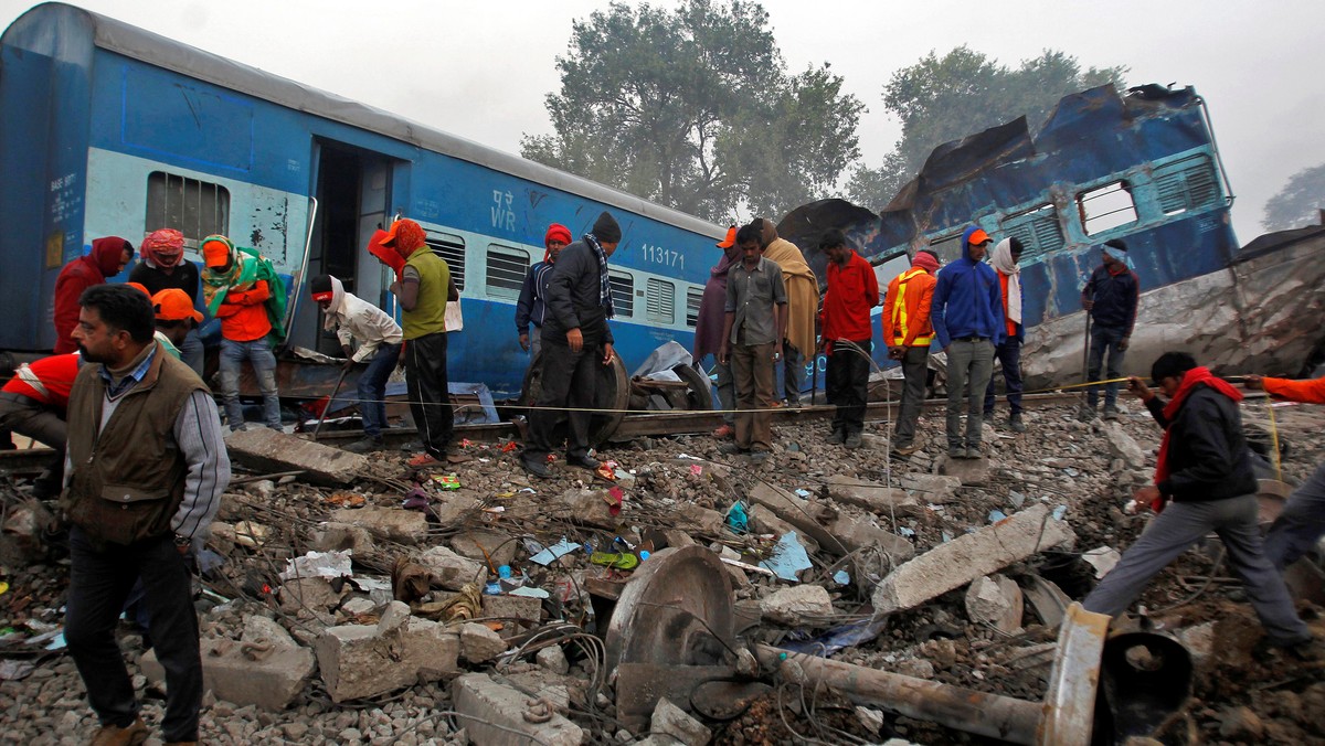 Rescue workers search for survivors at the site of Sunday's train derailment in Pukhrayan, south of Kanpur city