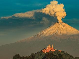 Popocatépetl. Czynny wulkan, zwany także El Popo, jest drugim co do wielkości w Meksyku. U podnóża wulkanu widać kościół usytuowany na piramidzie w Choluli, jeden z 365 obiektów sakralnych w tym mieście