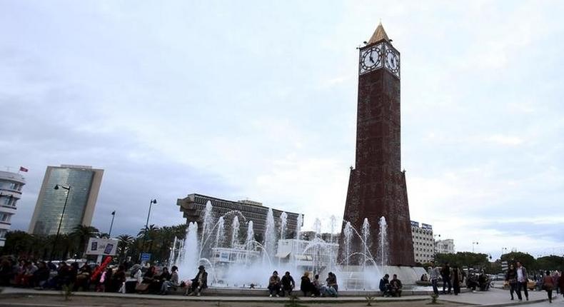 People sit in front of the clock tower at the end of Avenue Habib Bourguiba in Tunis, Tunisia, February 13, 2016. 