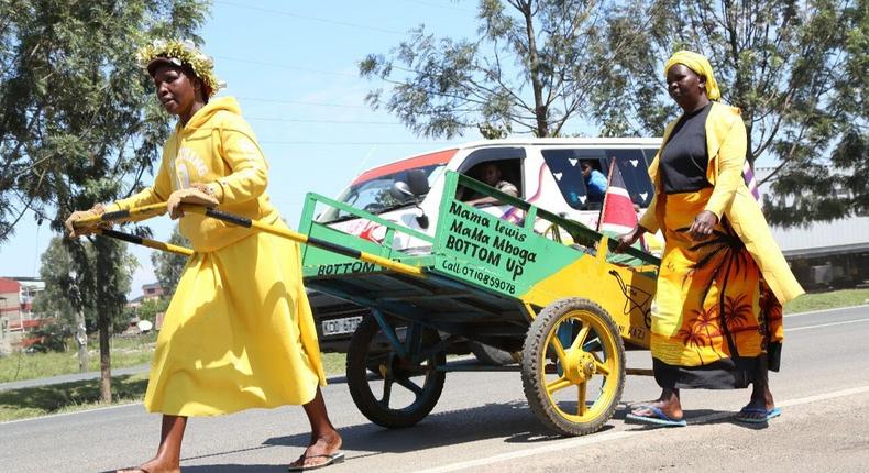 2 women push their mkokoteni enroute to Nairobi for President William Ruto's inauguration ceremony