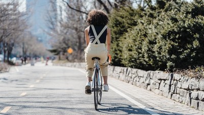 Cyclist riding bicycle on a city street [Photo: Blue Bird]