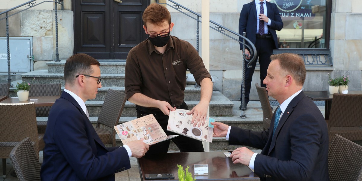 Na rynku brakuje m.in. pracowników branży HoReCa, czyli hoteli i restauracji. Na zdjęciu Mateusz Morawiecki i Andrzej Duda w kawiarni na Krakowskim Przedmiesciu, w dniu uroczystosci przekazania projektu ustawy o odbudowie Palacu Saskiego.