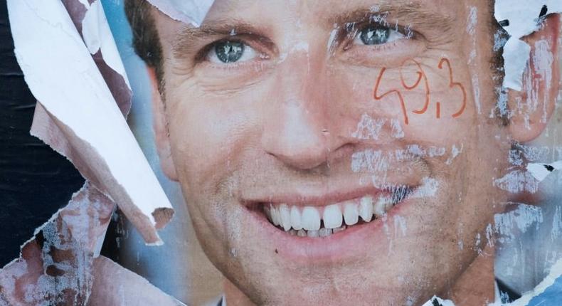 A vandalised electoral campaign poster of Emmanuel Macron in the run-up to the presidential election