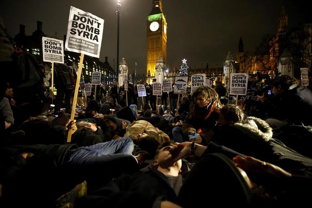 Anti-war protestors block the road during a demonstration outside the Houses of Parliament in London