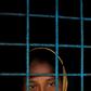 A Rohingya refugee who crossed the border from Myanmar this week stands at a window of a school used as a shelter at Kotupalang refugee camp near Cox's Bazar