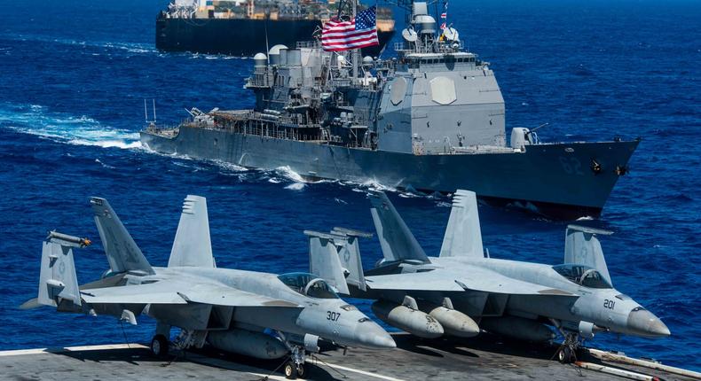 The Ticonderoga-class guided-missile cruiser USS Chancellorsville (CG 62) and the roll-on/roll-off container ship USNS 2nd Lt. John P. Bobo (T-AK 3008) are underway alongside the Navy's forward deployed aircraft carrier USS Ronald Reagan (CVN 76) during a photo exercise for Valiant Shield 2018.