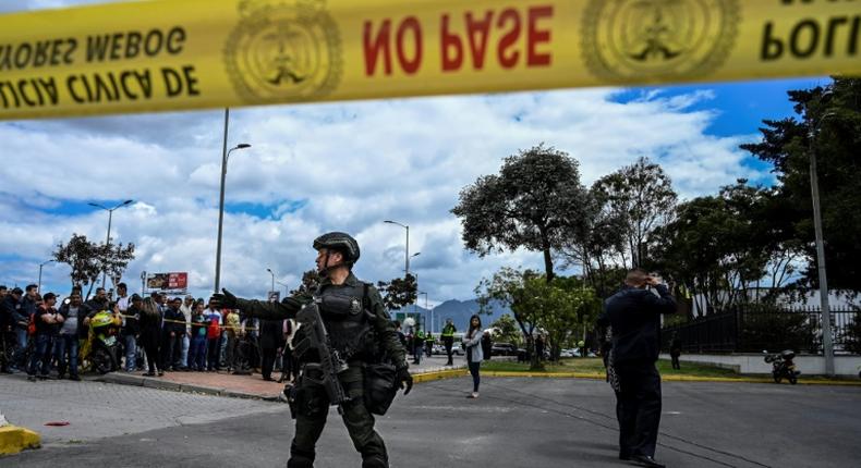Colombian security forces stand guard outside a police cadet training academy in Bogota, the site of a deadly car bomb attack blamed on ELN rebels