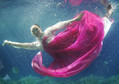 A promoter wearing a traditional hanbok performs in a water tank at the "Underwater Hanbok Fashion Show" during a photo call in Seoul