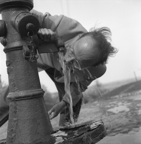 Maj 1958, Piaseczno, woj. Warszawa, Polska Mężczyzna pijący wodę z pompy. Fot. Romuald Broniarek/KARTA