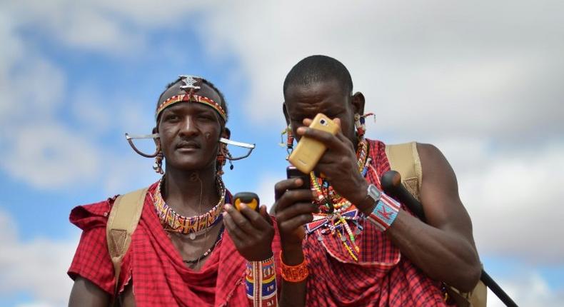 Kenyan Maasai 'Morans' (warriors) relay the GPS coordinates of the location of two-young lionesses they have been tracking on foot in the surrounding scrub, at the Selenkay Reserve, not far from Mount Kilimanjaro