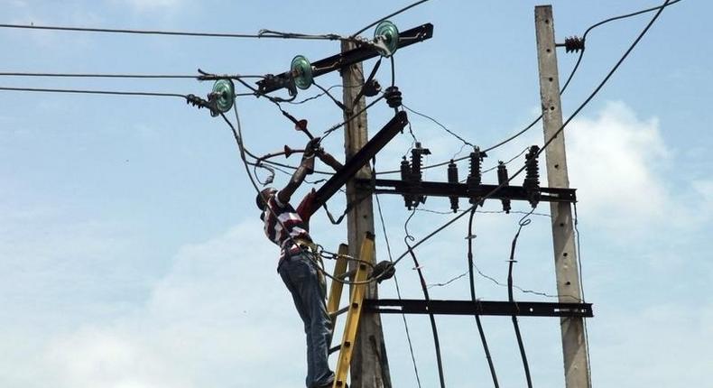 A power official works on an electric pole along a street in Nigeria's commercial capital Lagos. REUTERS/Akintunde Akinleye