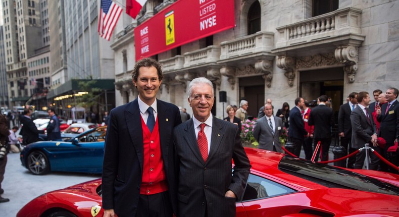 Chairman of Fiat Chrysler Automobiles and CEO of Exor, and Piero Ferrari, son of Ferrari Automotive Company founder Enzo Ferrari and Vice Chairman of the company, pose with a Ferrari outside the New York Stock Exchange after Ferrari's IPO on October 21, 2015.