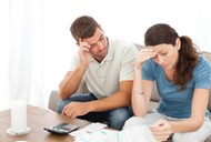 Worried couple doing their accounts in the living room