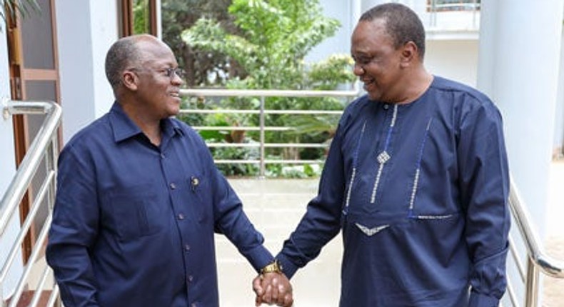 Tanzania's President Magufuli holds hands with Kenya's President Kenyatta