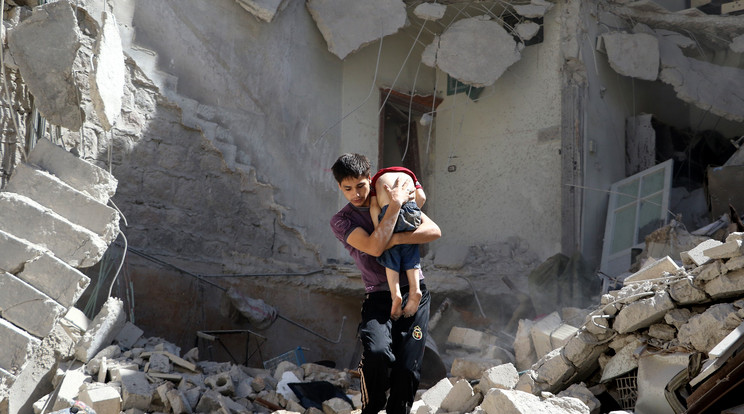 Egy kisfiút mentenek ki a romok alól a bombatámadás után / Fotó: Northfoto