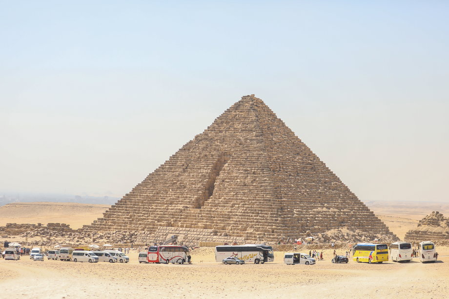 Tabuny turystów przed piramidami w Gizie.