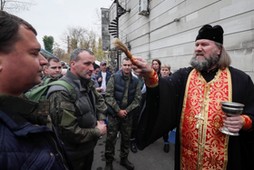 Prawosławny duchowny błogosławi mężczyzn zmobilizowanych na wojnę w Ukrainie