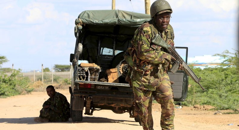 A Kenya Defense Force soldier runs for cover near the perimeter wall where attackers are holding up at a campus in Garissa April 2, 2015. REUTERS/Noor Khamis