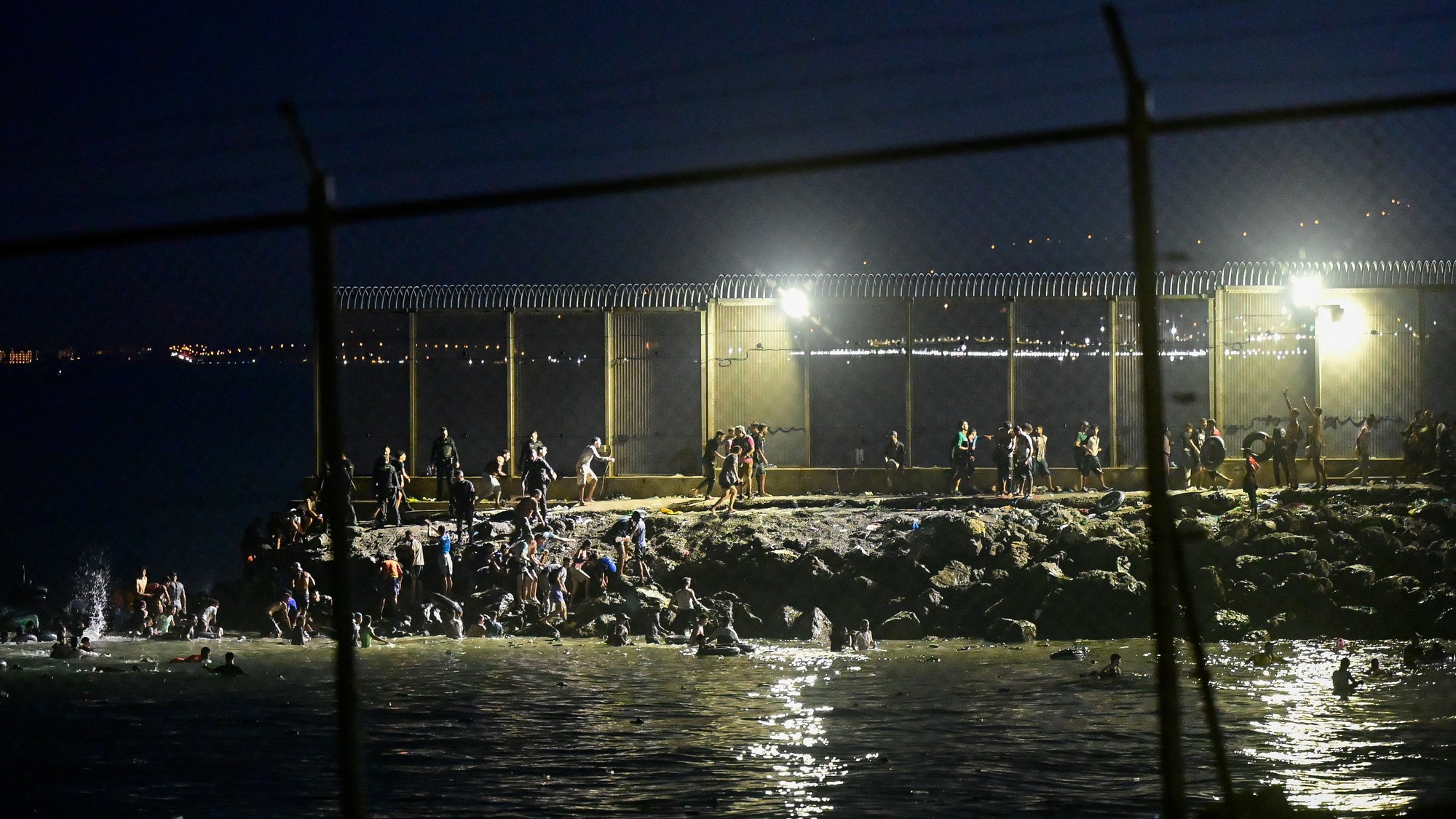 Migranti z Maroka v blízkosti hraničného plotu medzi španielskou enklávou Ceuta a Marokom, 30. júla 2026.
