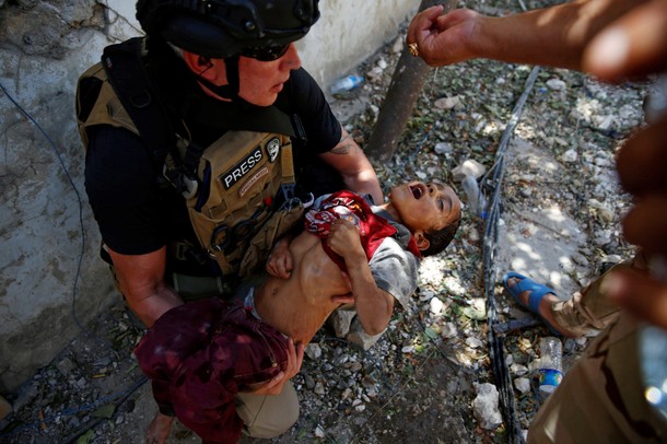 Iraqi soldiers from 9th Armoured Division give drops of water to a dehydrated baby rescued earlier b