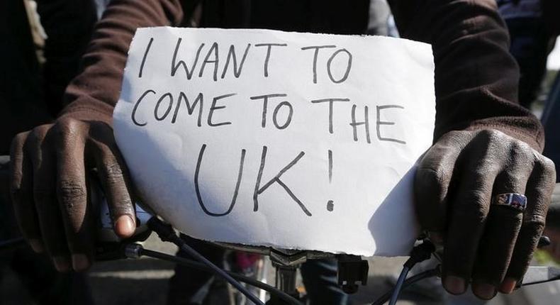 A migrant holds a placard which reads I want to come to the U.K. on his bicycle at the makeshift camp called The New Jungle in Calais, France, September 19, 2015. REUTERS/ Regis Duvignau