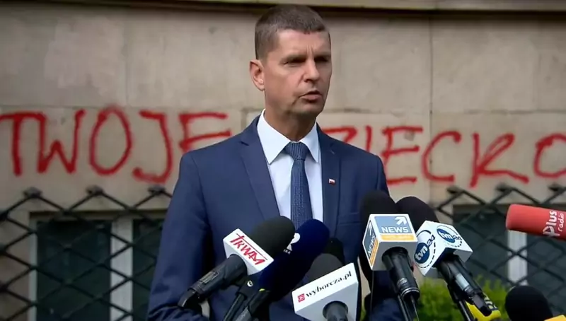Minister Piontkowski na tle budynku MEN z imonami dzieciaków LGBT