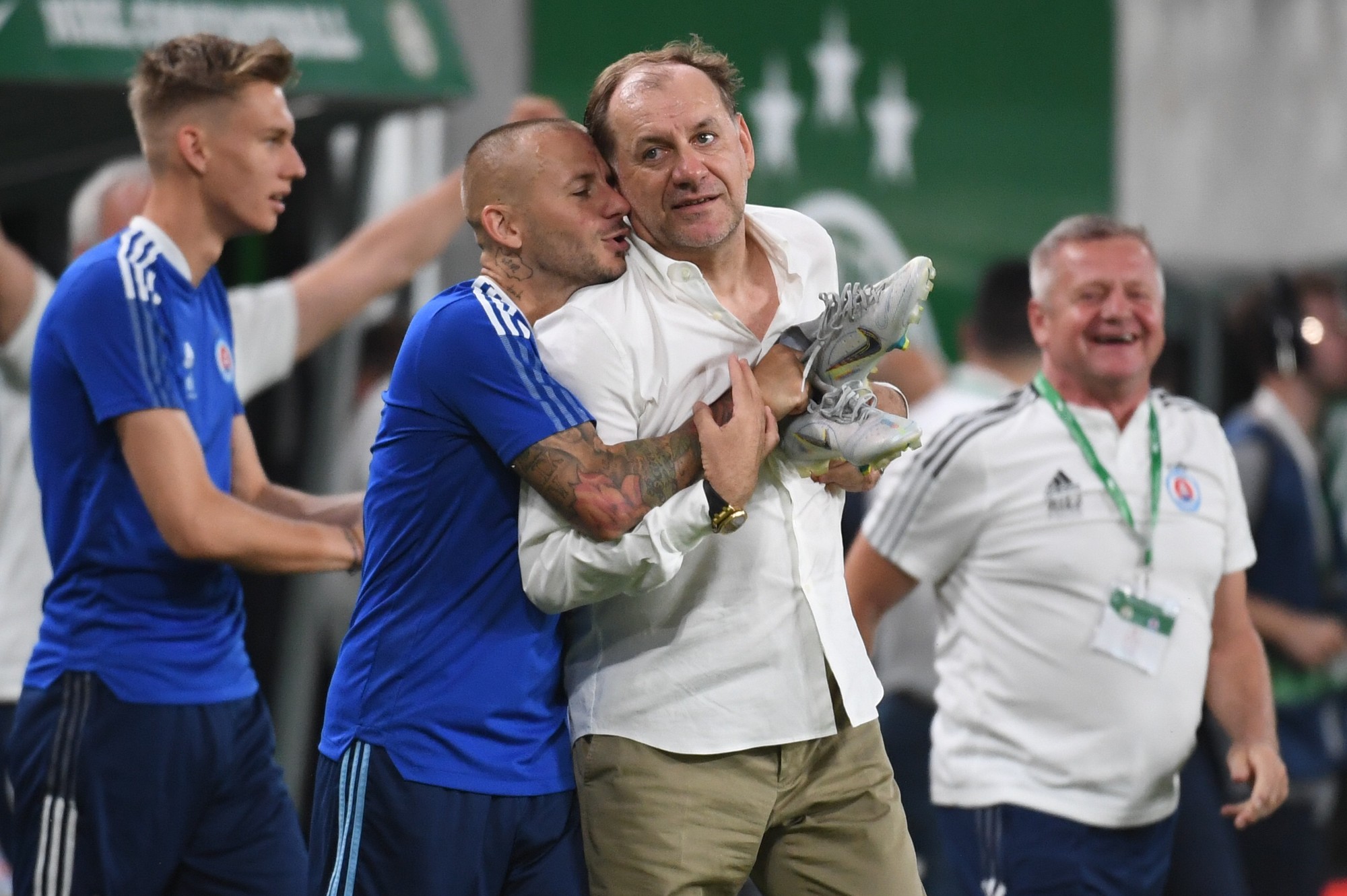 Tréner Slovana Vladimír Weiss st. (druhý sprava), jeho zverenec a syn Vladimír Weiss ml. sa objímajú po výhre v zápase 2. predkola Ligy majstrov Ferencváros Budapešť - Slovan Bratislava v Budapešti.