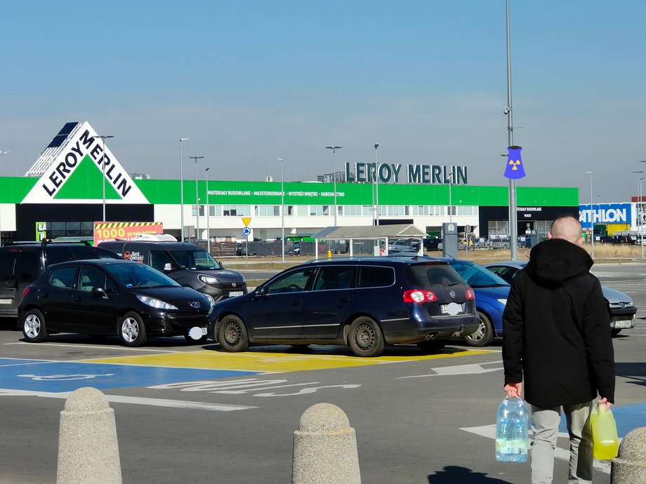 Klient opuszcza sklep Auchan. Obok są markety Leroy Merlin oraz Decathlon