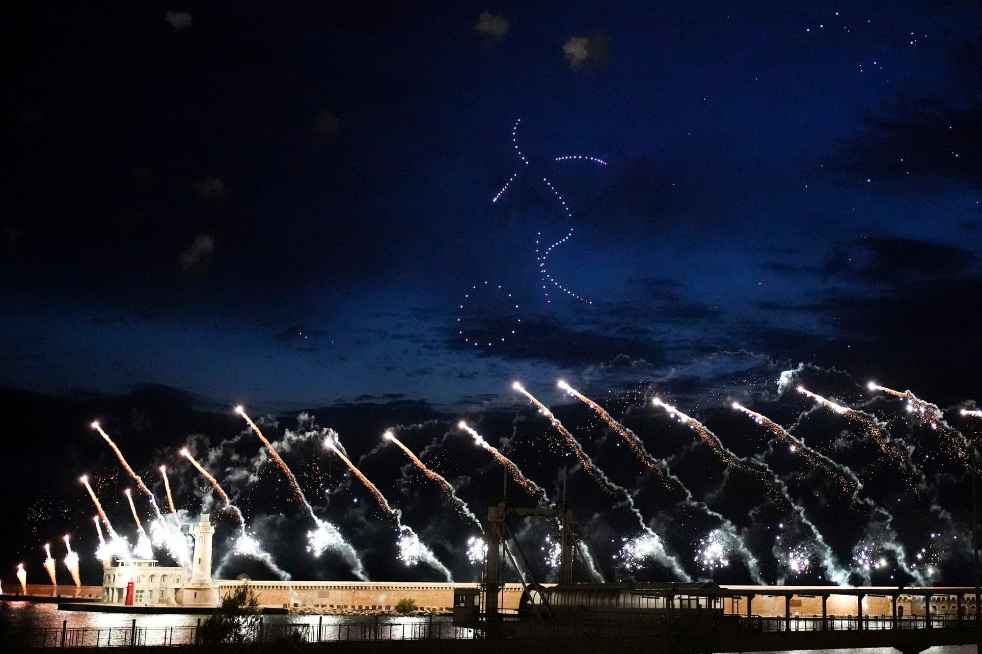 Setelné drony a ohňostroje rozžiarili oblohu v tvare olympijských kruhov počas príchodu olympijského ohňa do Francúzska.