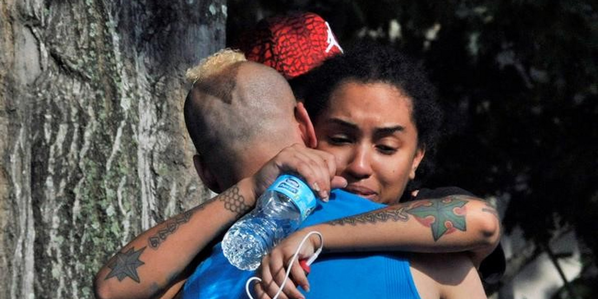 Friends and family members embrace outside the Orlando Police Headquarters during the investigation of a shooting at the Pulse nightclub in Orlando, Florida.