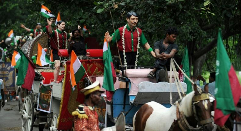 Carts with statues of former Mohun Bagan players are driven through the streets of Kolkata during celebrations marking the club's history in 2011