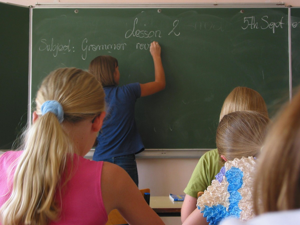 Nauczyciel piszący po tablicy. „Godziny czarnkowe” znikają z Karty nauczyciela