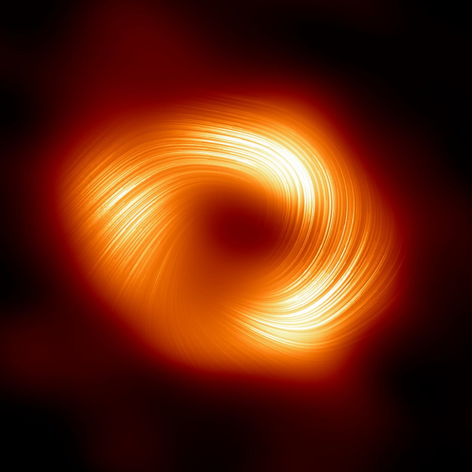 Una vista polarizada de Sagitario A* desde el Telescopio Horizonte de Sucesos.  Las líneas indican la dirección de polarización asociada con el campo magnético alrededor de la sombra del agujero negro.
