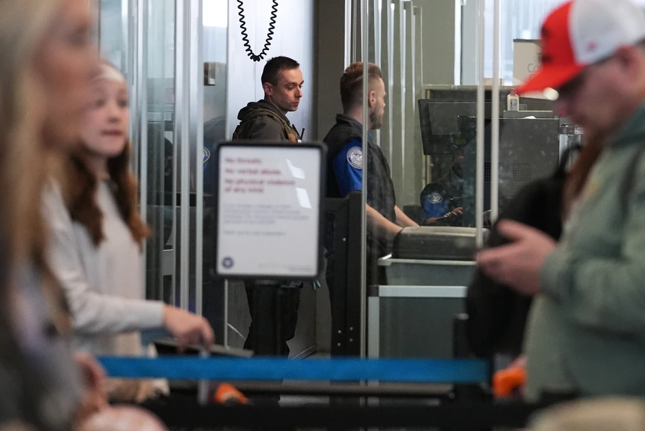 Agent ICE-a (L) i službenik TSA proveravaju prtljag na aerodromu O’Her u Čikagu 24. marta