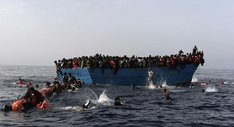 Migrants wait to be rescued by members of Proactiva Open Arms NGO in the Mediterranean Sea, some 12 nautical miles north of Libya, on October 4, 2016