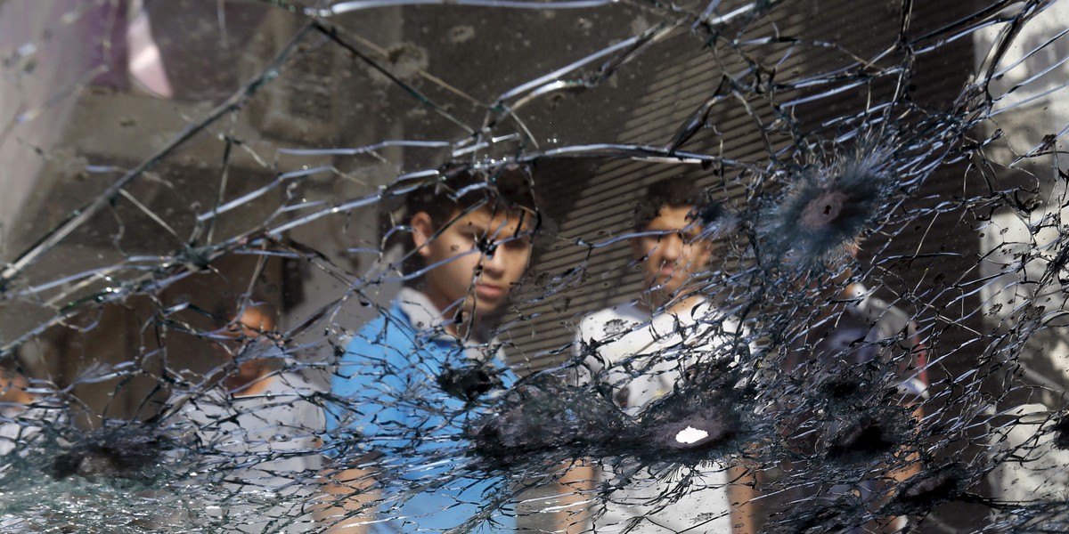 Boys gather where one of the shells from fighting in southern Syria hit a bustling market place in the town of Ramtha, Jordan, June 25, 2015.